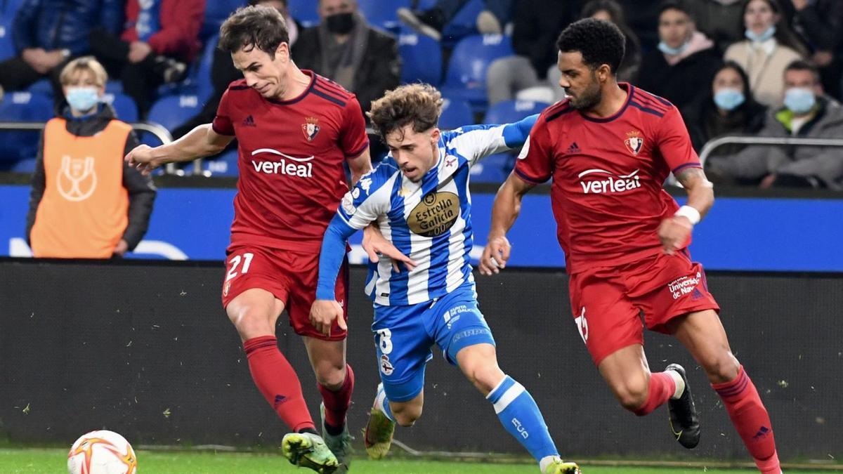 Mario Soriano, entre dos jugadores de Osasuna. |  // CARLOS PARDELLAS