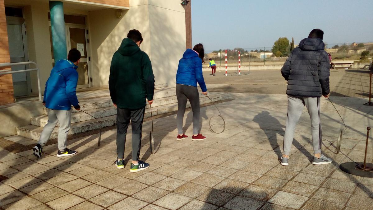 Estudiantes del IES Reyes Católicos, sección Sádaba, con uno de los juegos antiguos que pueden practicar durante los recreos.