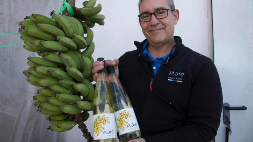 Carlos Guevara, uno de los propietarios de Bodegas Platé, con dos botellas de su vino de plátano.