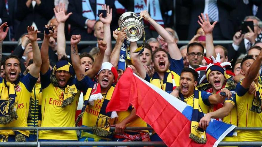 Los jugadores del Arsenal levantan el trofeo de campeones.