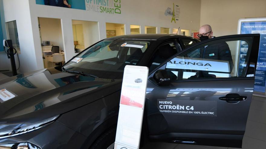 Un hombre ve un coche en el concesionario Dalonga. | // GUSTAVO SANTOS