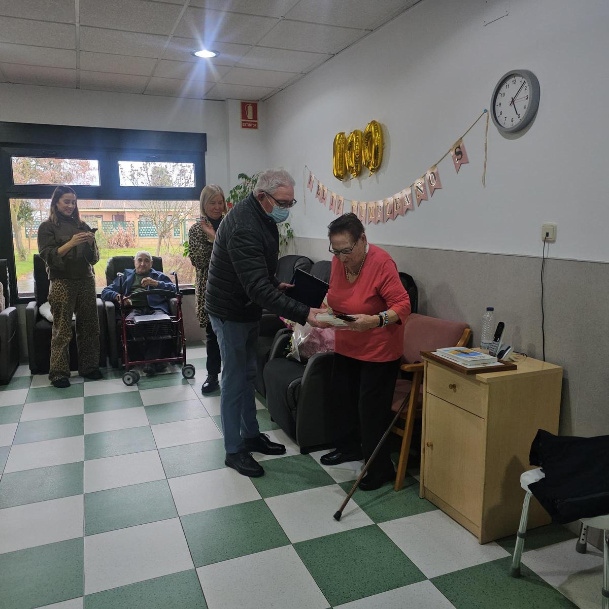 El alcalde de Santa Cristina hace entrega de la placa a Manuela Cid, durante el acto de homenaje.