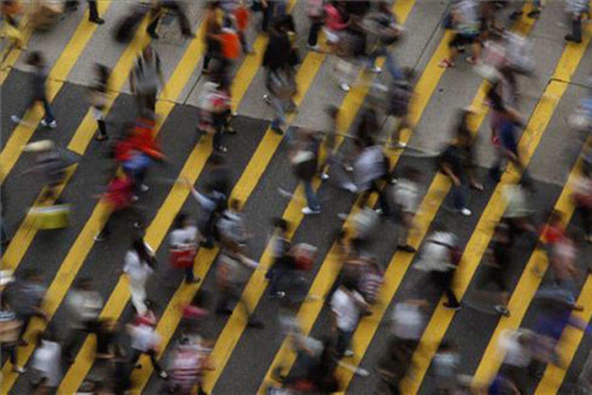 Un grup de vianants travessa un carrer del districte de Mong Kok (Hong Kong) on viuen 130.000 habitants per quilòmetre quadrat.