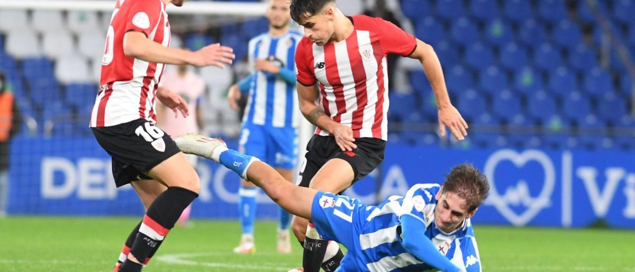 Noel cae derribado ante dos jugadores del Bilbao Athletic en el partido en Riazor. |  // CARLOS PARDELLAS