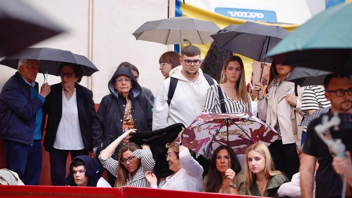 Varias personas aguardan bajo los paraguas la salida del Rescatado. El Domingo de Ramos, finalmente, pudieron salir todas las cofradías.