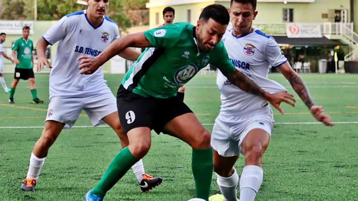 Adrián, delantero del Atl. Paso, es presionado por dos futbolista del Tenisca en el choque de las Fiestas de El Pino. | | Ó. SIMÓN