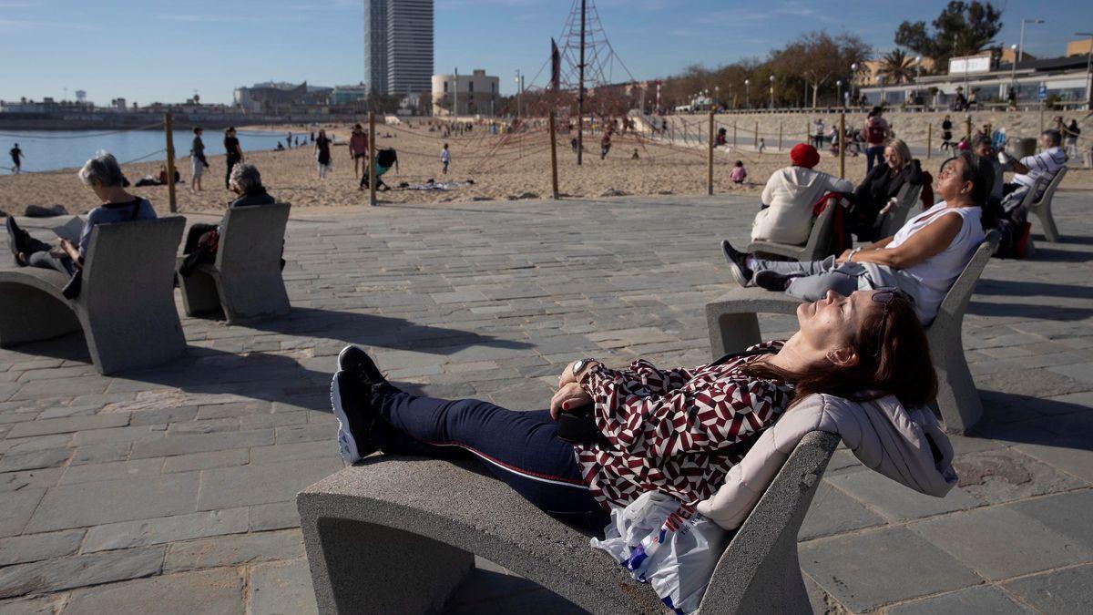 Diverses persones prenent el sol aquest diumenge a la platja del Bogatell