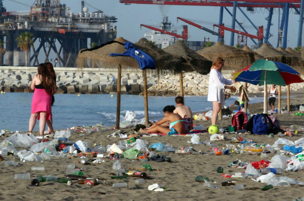 Los operarios de los servicios de limpieza trabajan para dejar la playa en óptimas condiciones tras una larga noche de fiesta en la arena