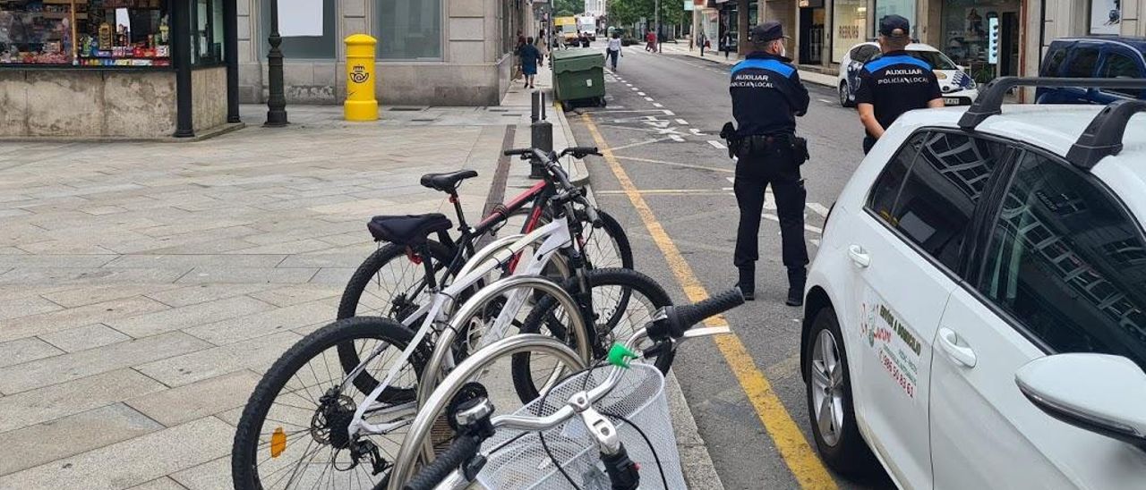 Dos auxiliares de policía vigilando en Arzobispo Lago y Praza de Galicia.