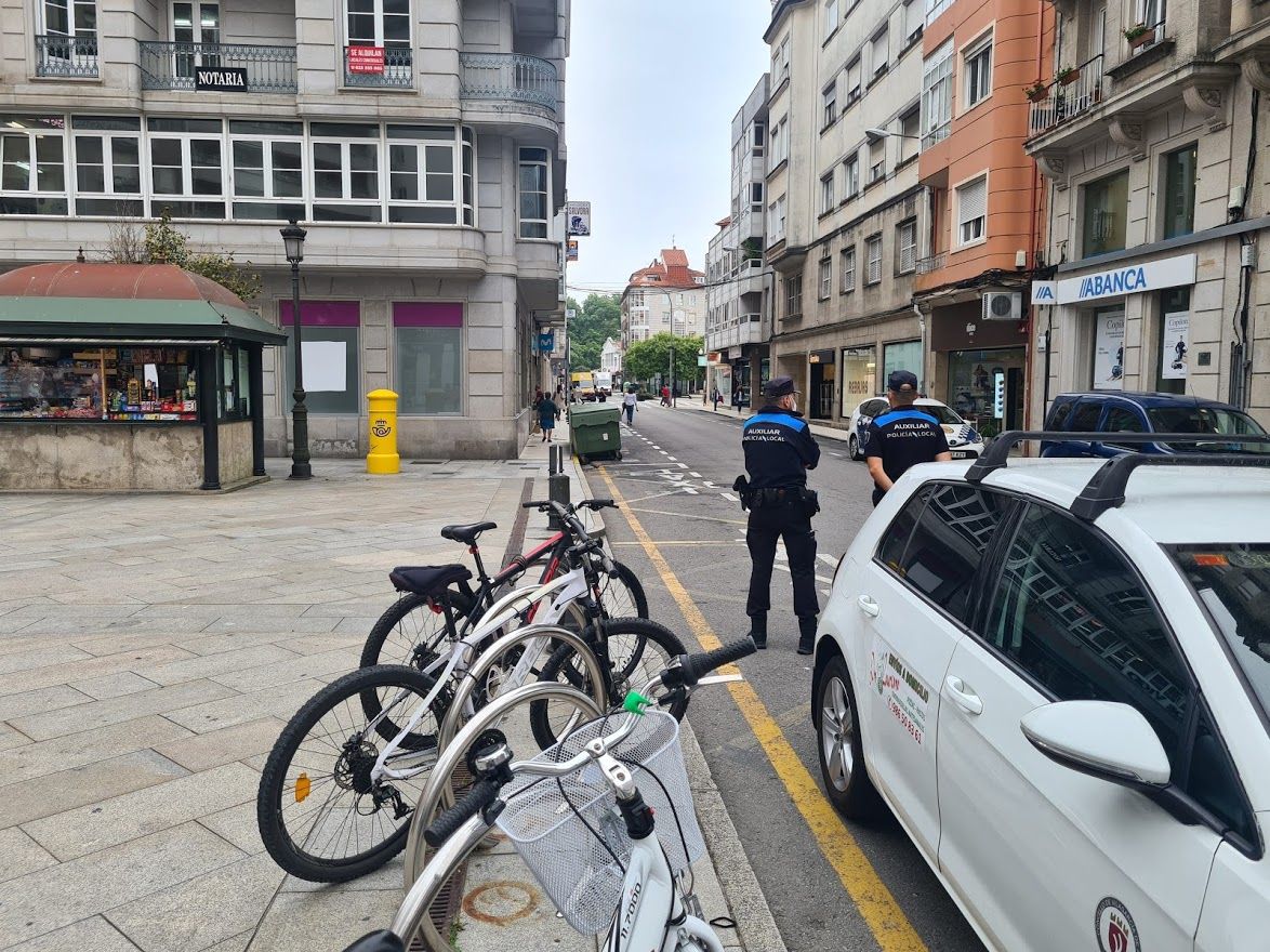 Dos auxiliares de policía vigilando en Arzobispo Lago y Praza de Galicia.