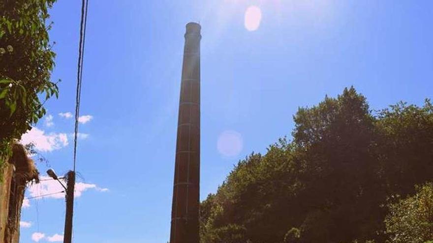 Un grupo de vecinos con la chimenea de la tenería al fondo.