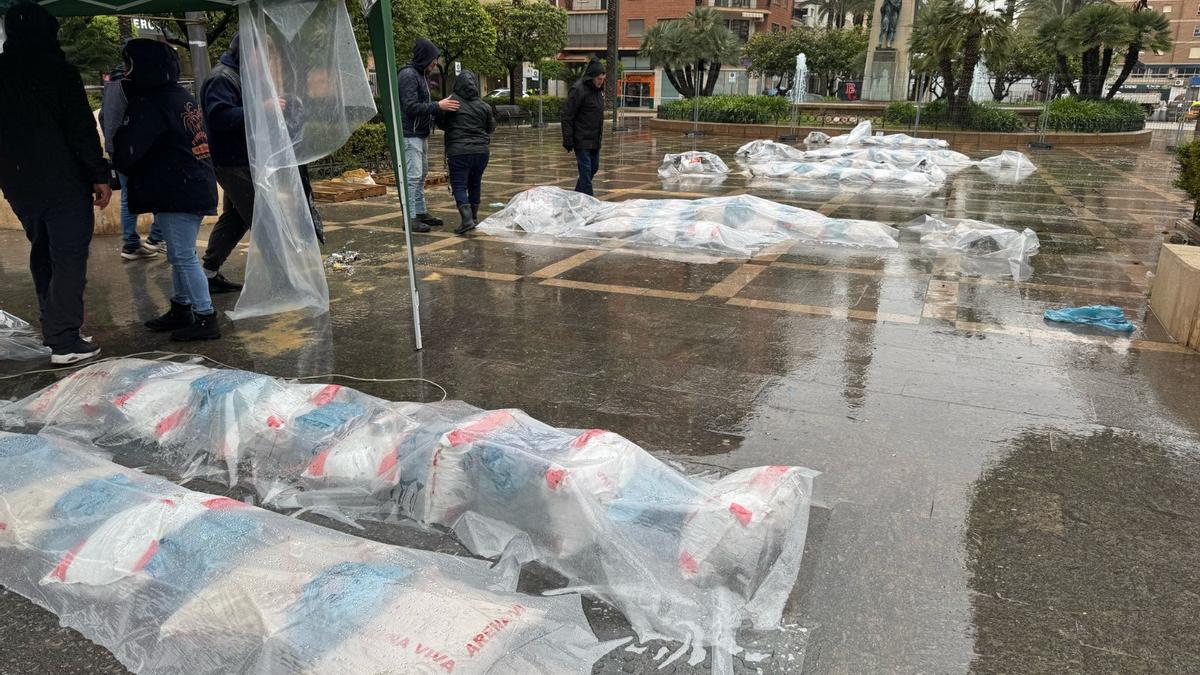 Los técnicos protegen de la lluvia la pólvora de la mascletà de Alzira.