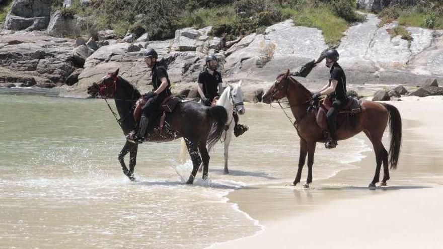 Algunos de los jinetes con sus caballos durante la ruta ecuestre por la costa de Cangas. // Santos Á.