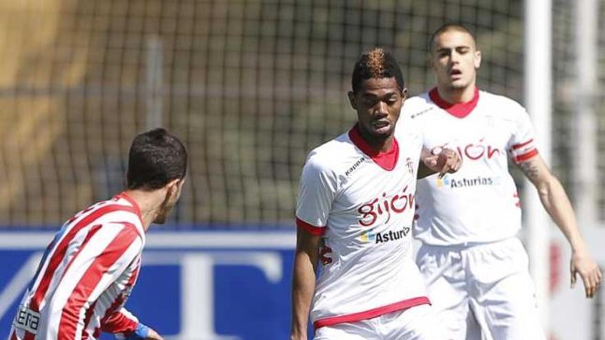 Adama Touré encara a un jugador del Atlético B, con Alain al fondo.