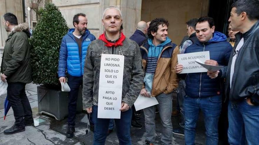 La vecina de Veriña Angelina Menéndez, en primer término, lee en el Pleno el manifiesto de Asturias por un Aire Sano, mientras varios compañeros portan carteles de la manifestación del domingo, al fondo.