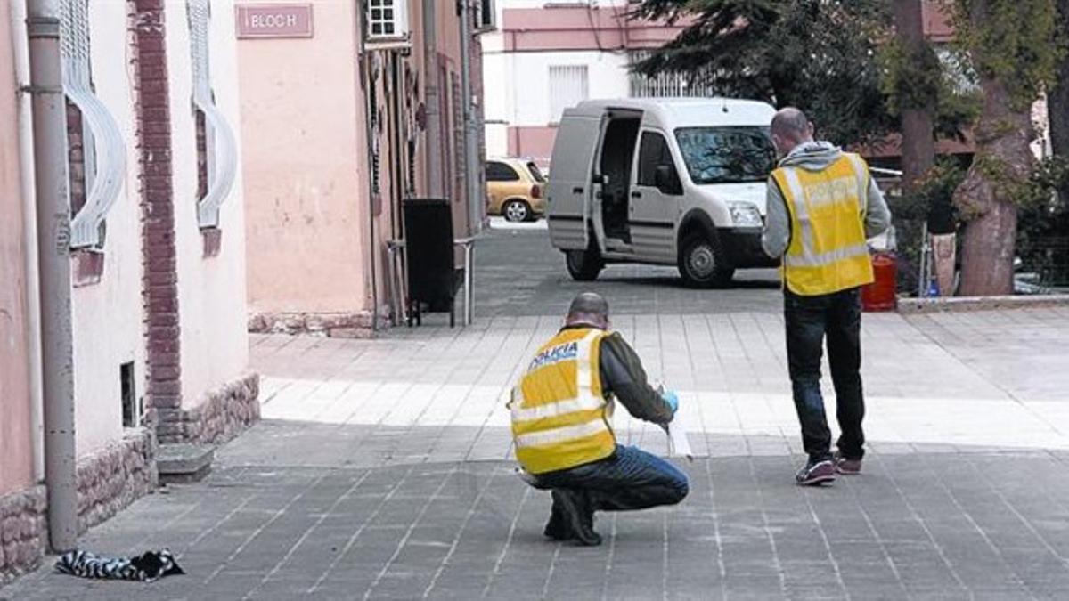 Dos mossos recogen muestras en el barrio de La Mariona, en Lleida, tras el suceso.