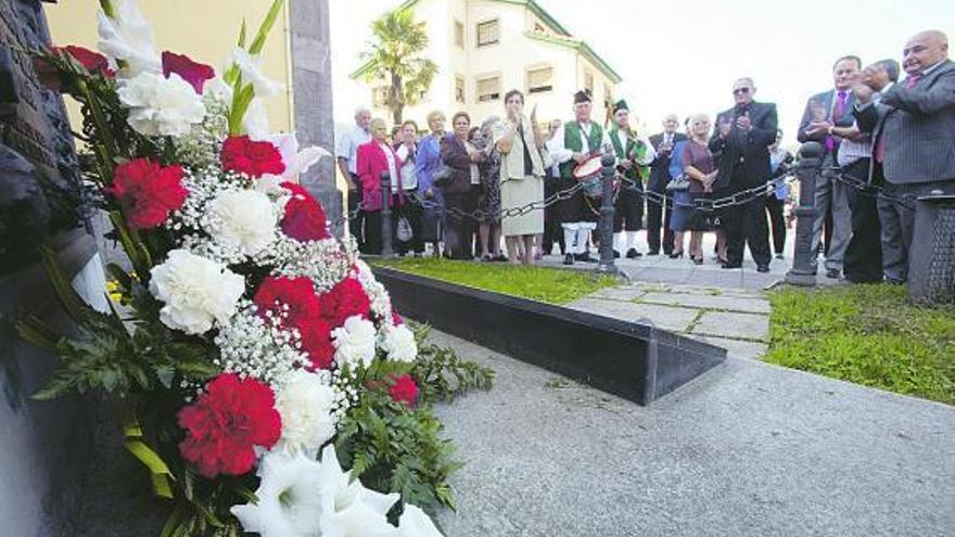 Los asistentes aplauden tras la ofrenda floral en el monumento a los mineros fallecidos.