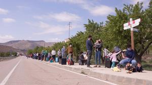 Los vecinos de La Mata (Els Ports, Castellón), en fila durante su protesta en la carretera del pueblo con un línea MAT.