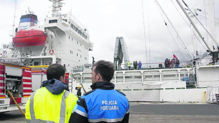 Policía portuaria y otros efectivos de seguridad actúan en un incendio declarado en un barco en el Puerto de Marín.  // Santos Álvarez