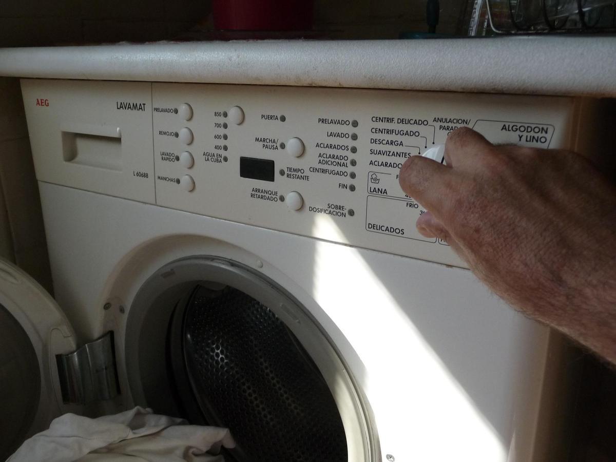 Una persona programa una lavadora doméstica, en una foto de archivo. 