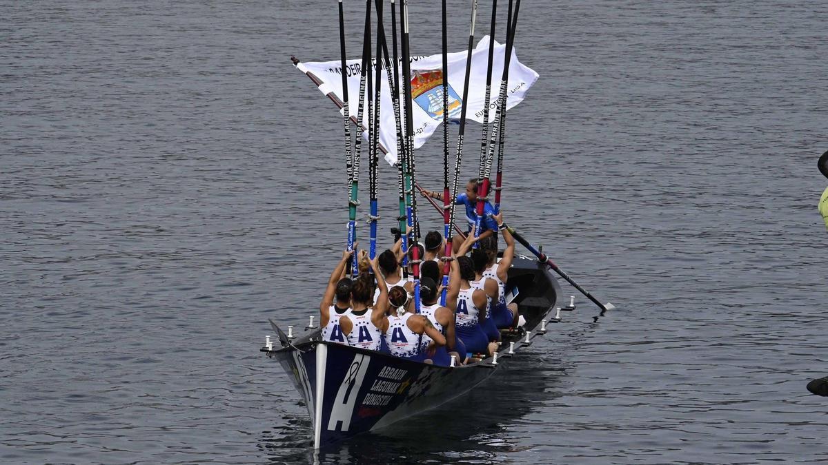 La tripulación de Donostia Arraún Lagunak levanta los remos para celebrar su triunfo en Bueu.