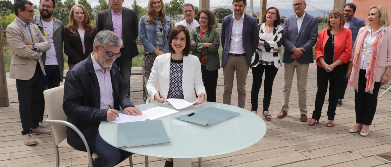 Josep Alandete y Diana Morant firman el acuerdo entre el PSOE y Compromís Més Gandia Unida ante el resto de concejales del nuevo gobierno de la ciudad.