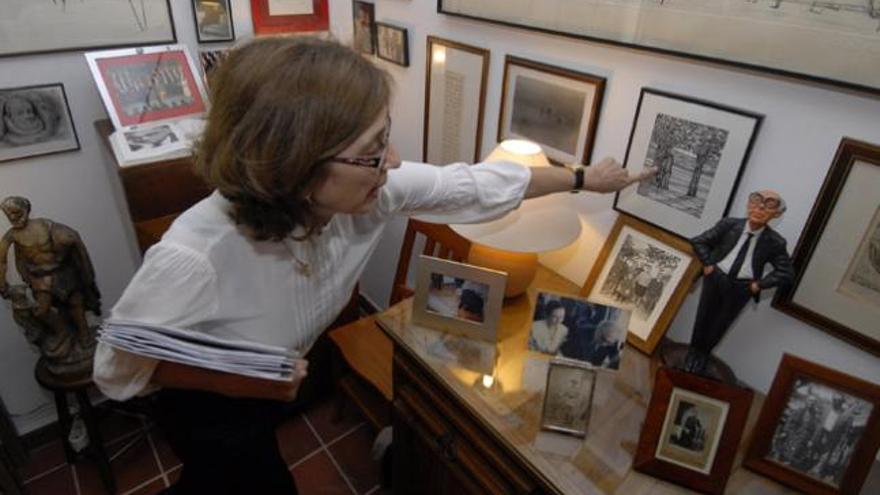 Pilar del Río muestra, ayer, un cuadro sobre el abuelo de José Saramago junto a una pequeña figura del escritor portugués, en A Casa. i ADRIEL PERDOMO