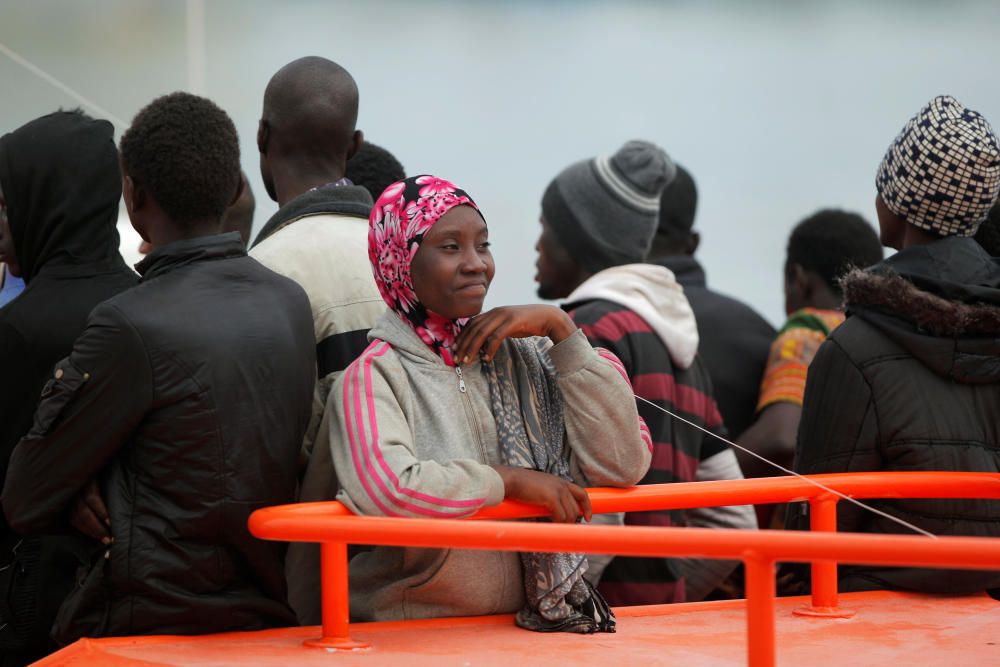 A migrant smiles as she stands on a rescue boat ...