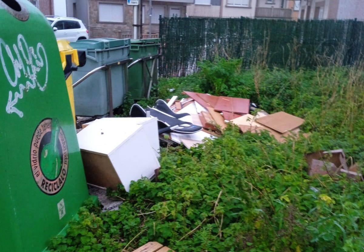 Restos de mobiliario arroxados nunha parcela en Fisterra.