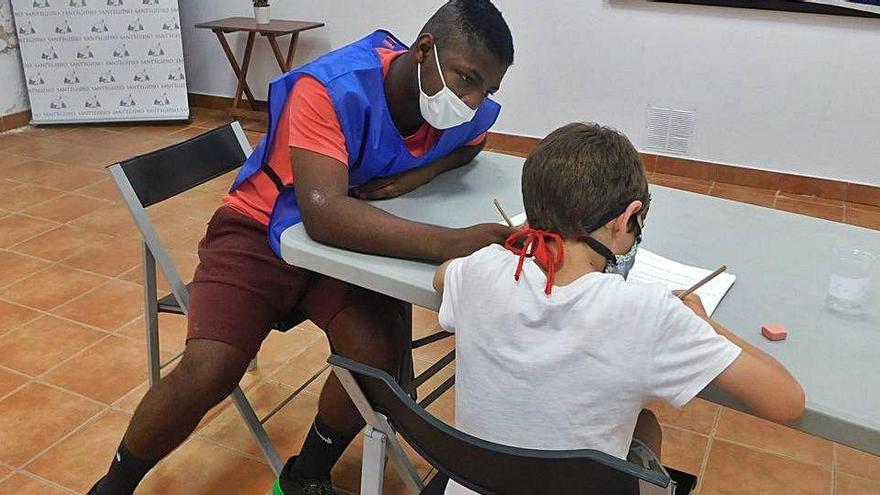 El voluntari Pau Perpiñán fa classe de reforç en una aula de la Casa de la Pau de la Comunitat de Sant Egidi