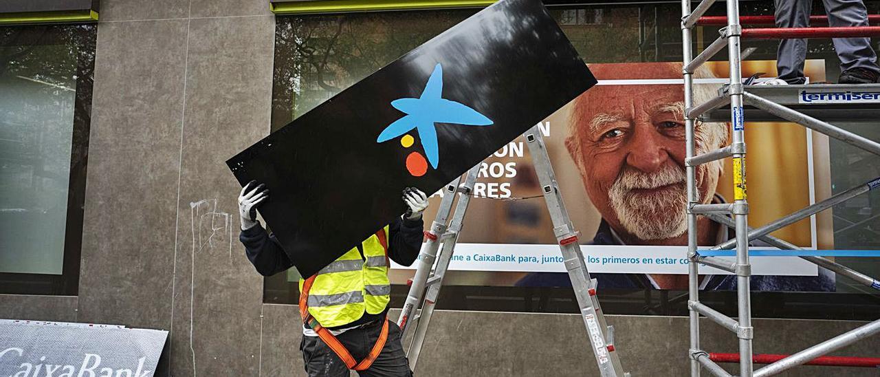 Cambio de logo en una oficina del barrio de Algirós de València, ayer. | GERMÁN CABALLERO