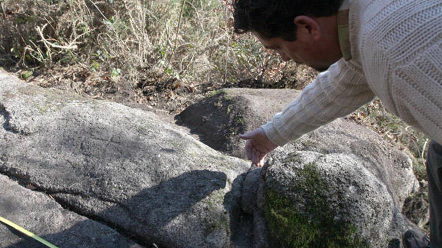 Calros Solla examina a pedra antropomorfa que atopou en Serrapio.  // Bernabé/Cris M.V.