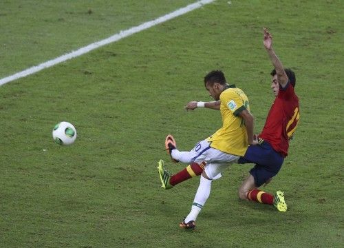 Brazil's Neymar (L) strikes the ball past Spain's Alvaro Arbeloa for a goal during the Confederations Cup final soccer match in Rio de Janeiro