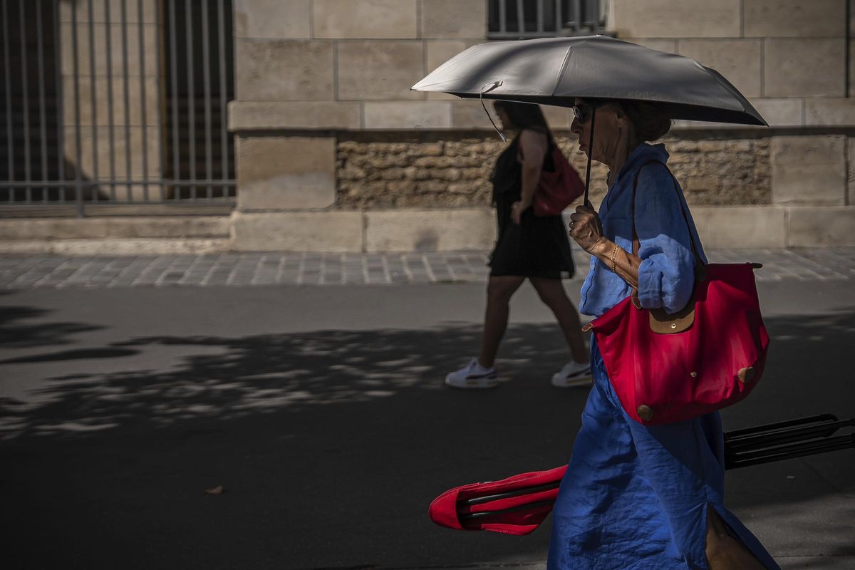 Una mujer se protege del sol con un paraguas en París, este martes.