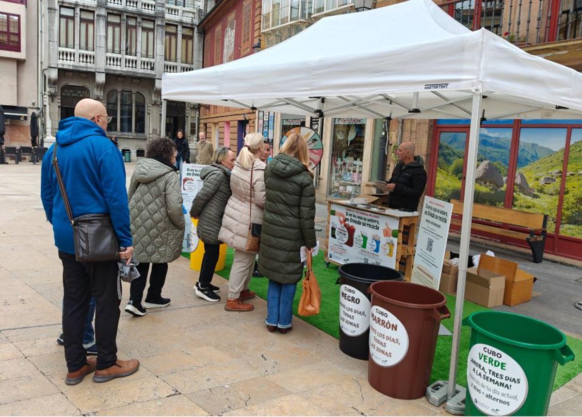 Vecinos y vecinas de Oviedo informándose en el stand de la campaña «Si en tu casa se separa, en Oviedo se recicla».
