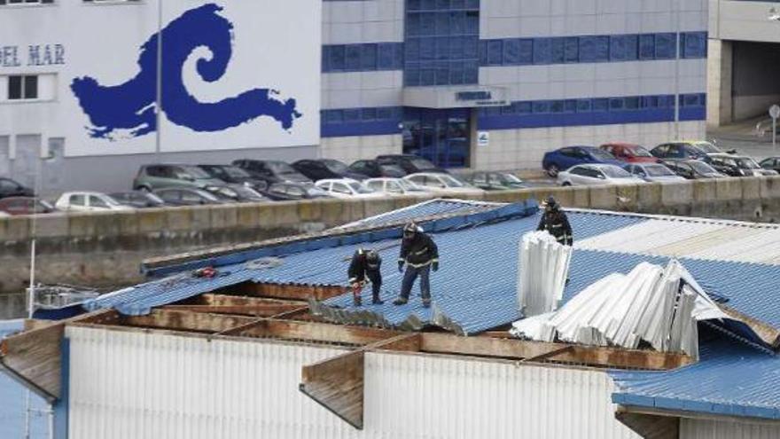 El fuerte viento levantó chapas de la cubierta de la lonja y obligó a actuar a los bomberos.  // Jorge Santomé