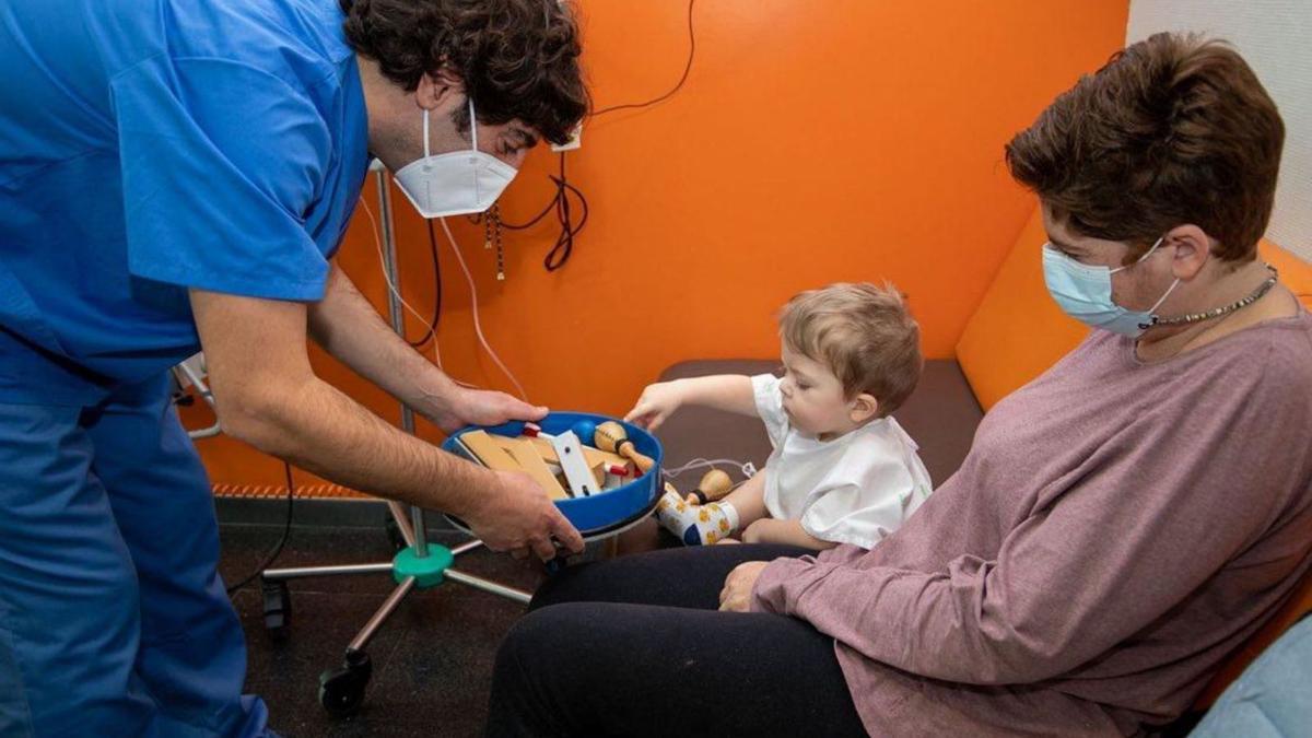 Un pequeño y su padre, durante una sesión de musicoterapia en Son Espases.