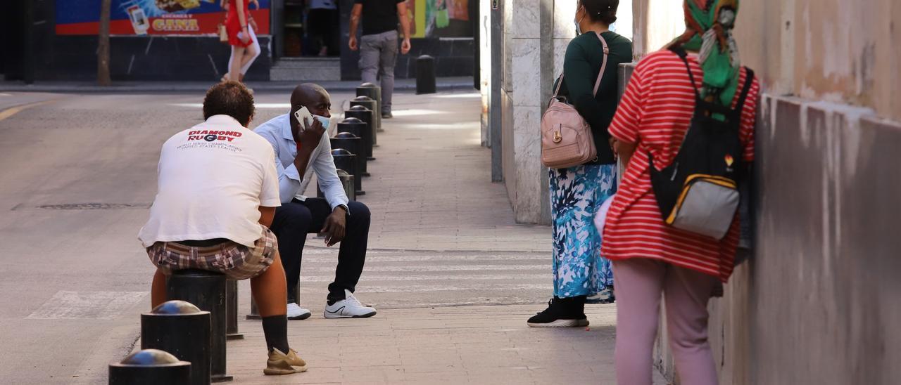 Personas aguardan en las inmediaciones del comedor social del centro de Murcia. / JUAN CARLOS CAVAL
