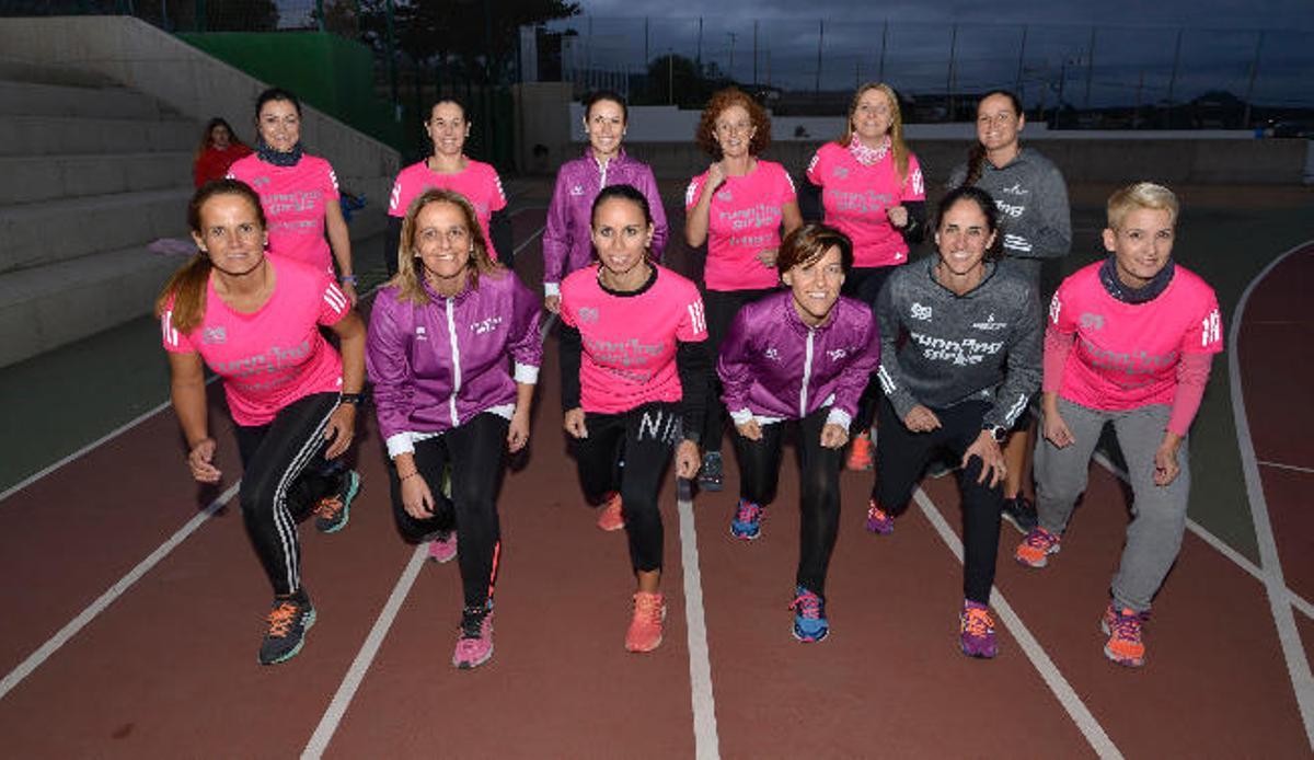Doce de las 30 'Running Girls' que van a participar posan en la pista de atletismo antes de un entrenamiento.