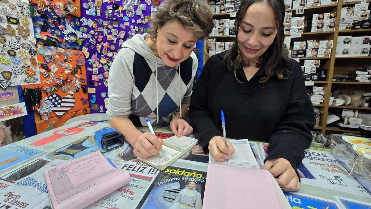 Unas dependientas hacen facturas de forma manual, en una imagen de archivo.