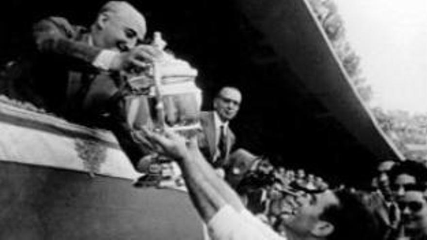 Franco hace entrega de una copa de fútbol.