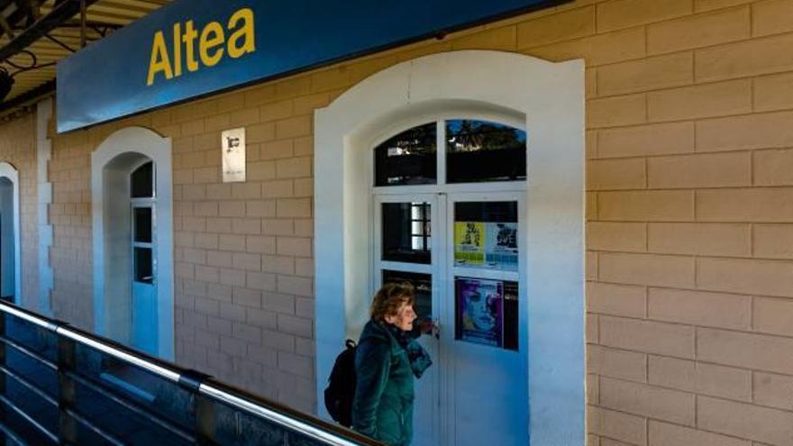 Una mujer de edad intentando acceder a la estación del trenet en Altea, cerrada a cal y canto.