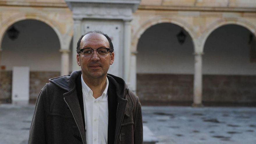 Isidro Sánchez, en el edificio histórico de la Universidad de Oviedo, ante la estatua de Valdés-Salas. | | F. RODRÍGUEZ