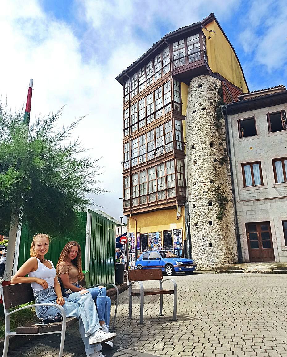 Claudia y Andrea Bustillo, con una casa tradicional enclavada en la muralla medieval al fondo.