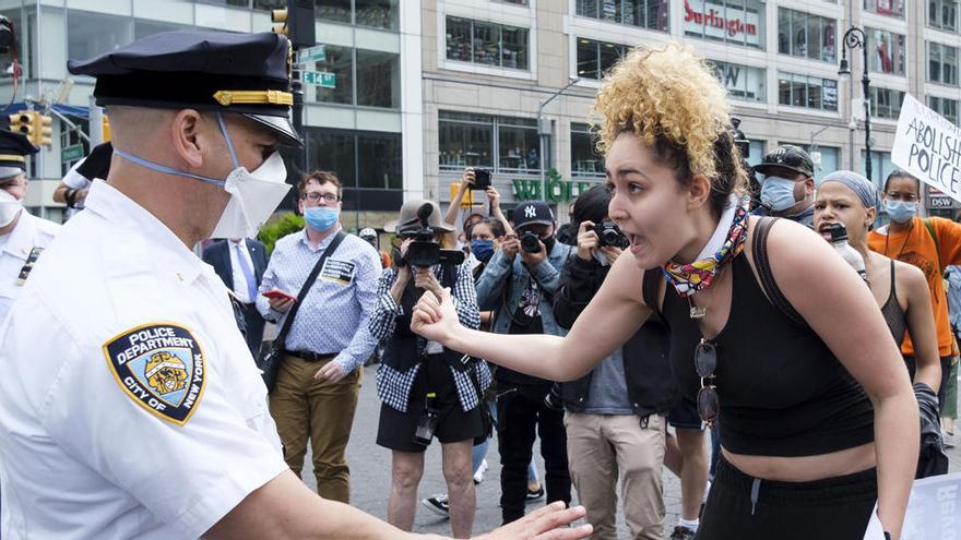 Una mujer grita a los oficiales de policía durante una protesta en respuesta a la muerte de George Floyd.