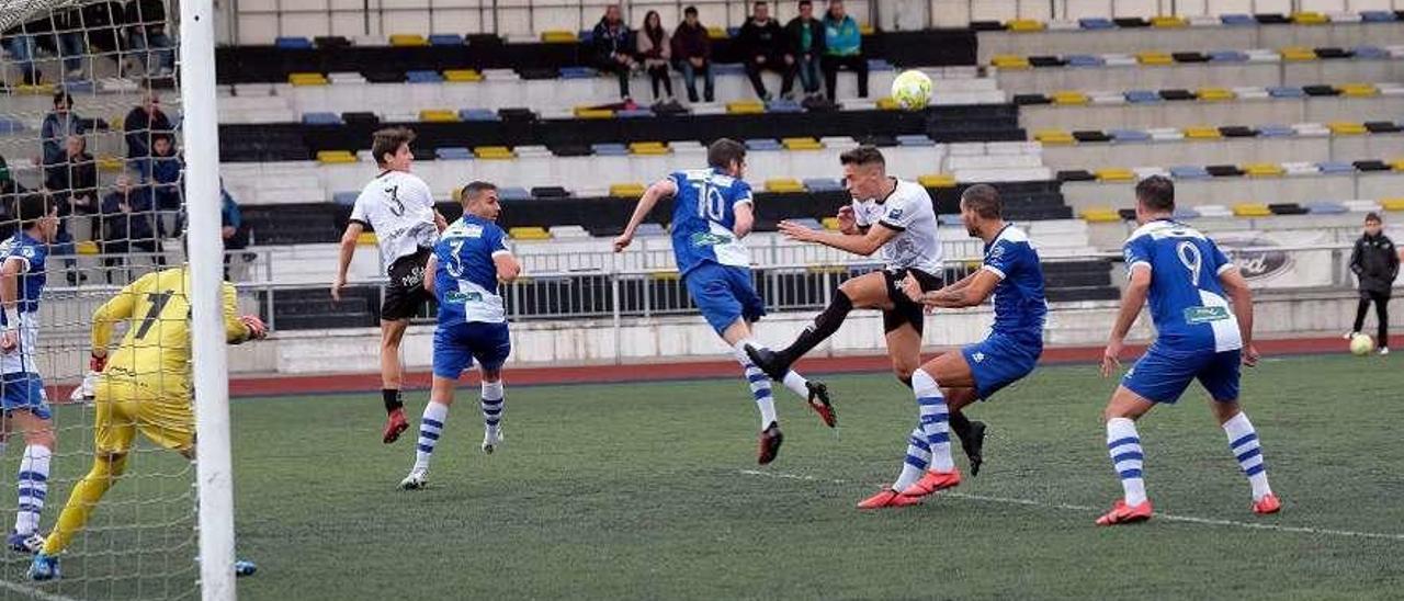 Keko Hevia, en el centro, trata de rematar un balón en un córner ante el Tuilla.