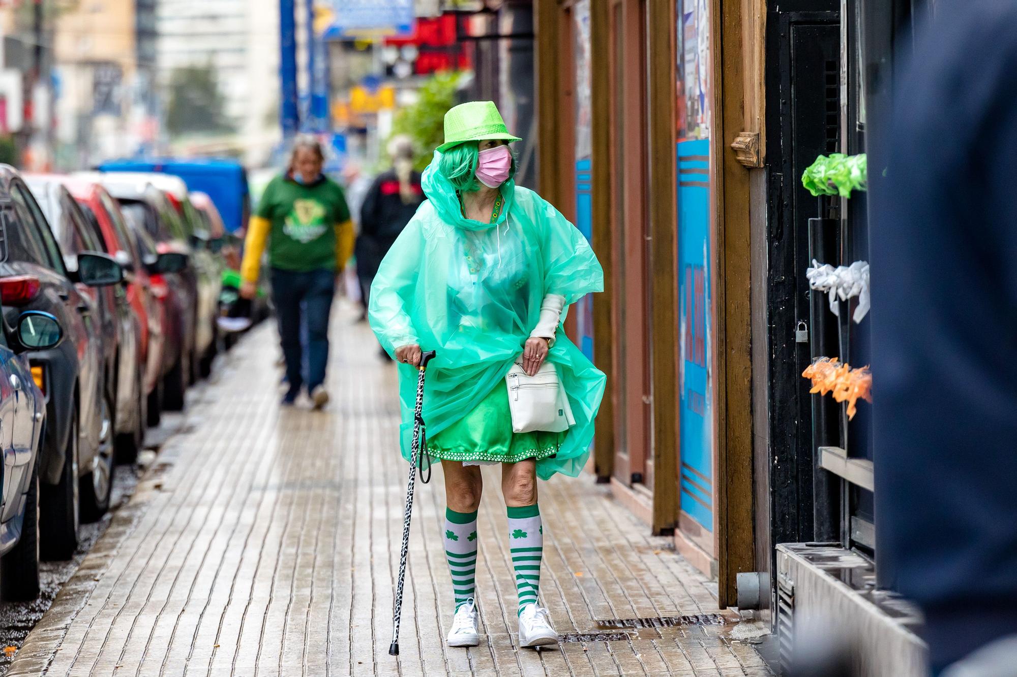 Esta tradicional fiesta llena de verde las calles de la zona inglesa | Los turistas se refugian en terrazas y bares ante las precipitaciones pero no desisten de la celebración