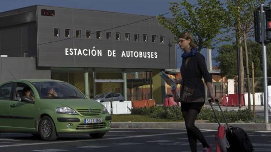 Una joven turista maleta a cuestas cruza la calle junto al edificio de la nueva estación de autobuses de Alicante