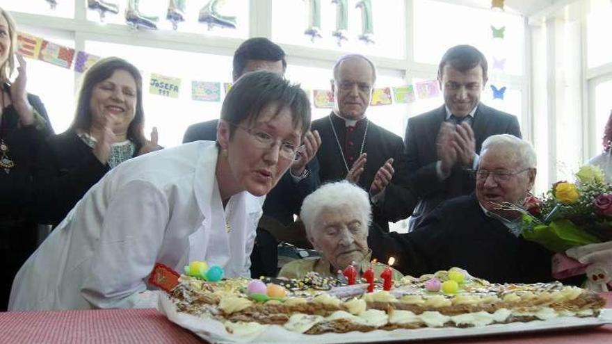 Vicenta Freire, directora de la residencia, sopló las velas de Josefa Álvarez, que ayer cumplió 111 años. // Jesús Regal