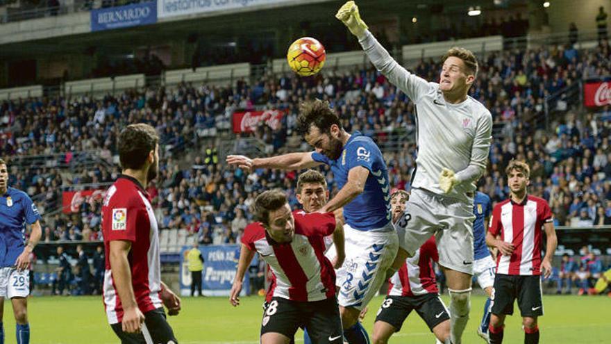 Remiro, meta del filial bilbaíno, despeja el esférico pese al intento de remate de Borja Gómez, en el Tartiere.